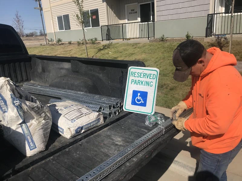 Signs & Parking Blocks installation of reserved parking sign on job site