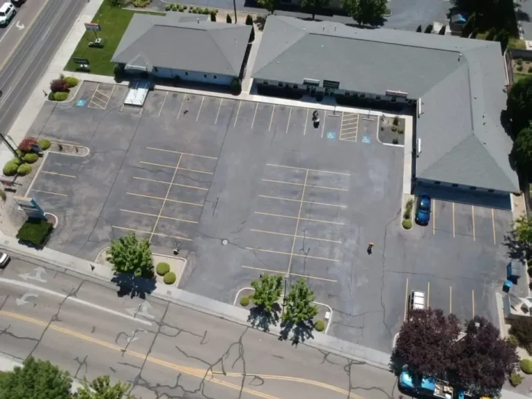 Aerial view of commercial parking lot before sealcoating and restriping in Idaho
