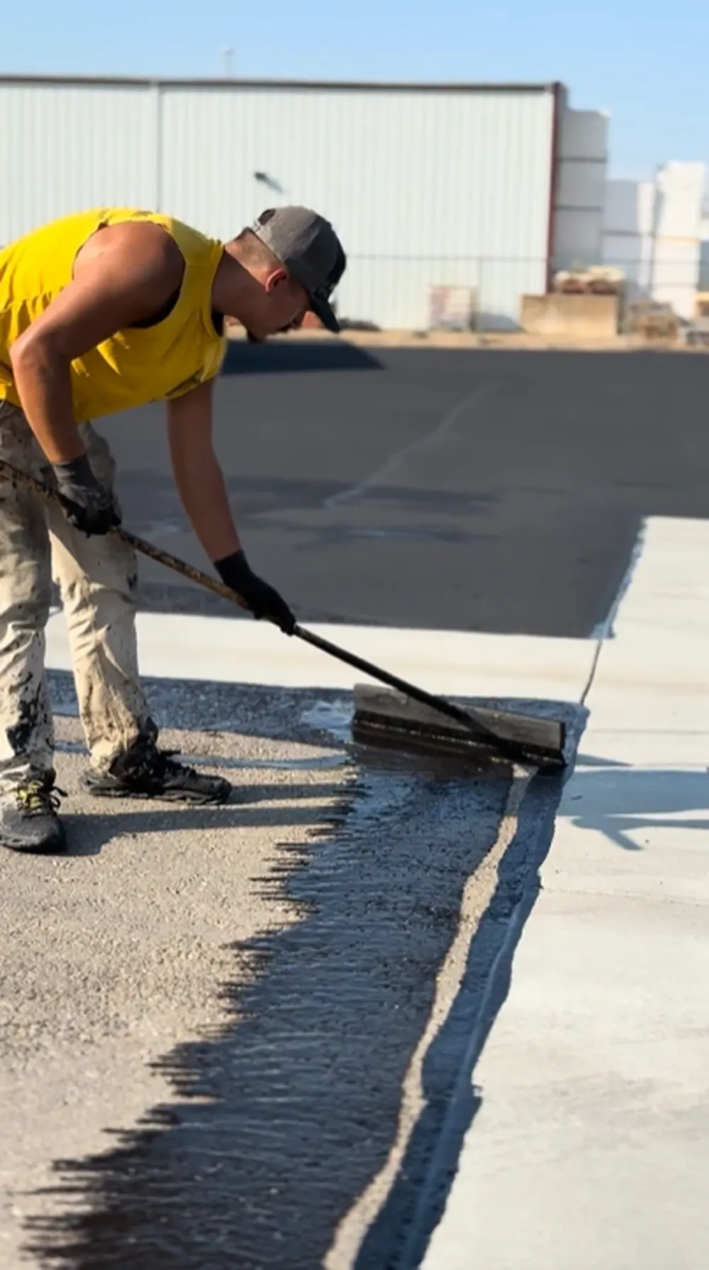 Superior Striping Technician Sealcoating Commercial Parking Lot Next to Warehouse in Nampa ID