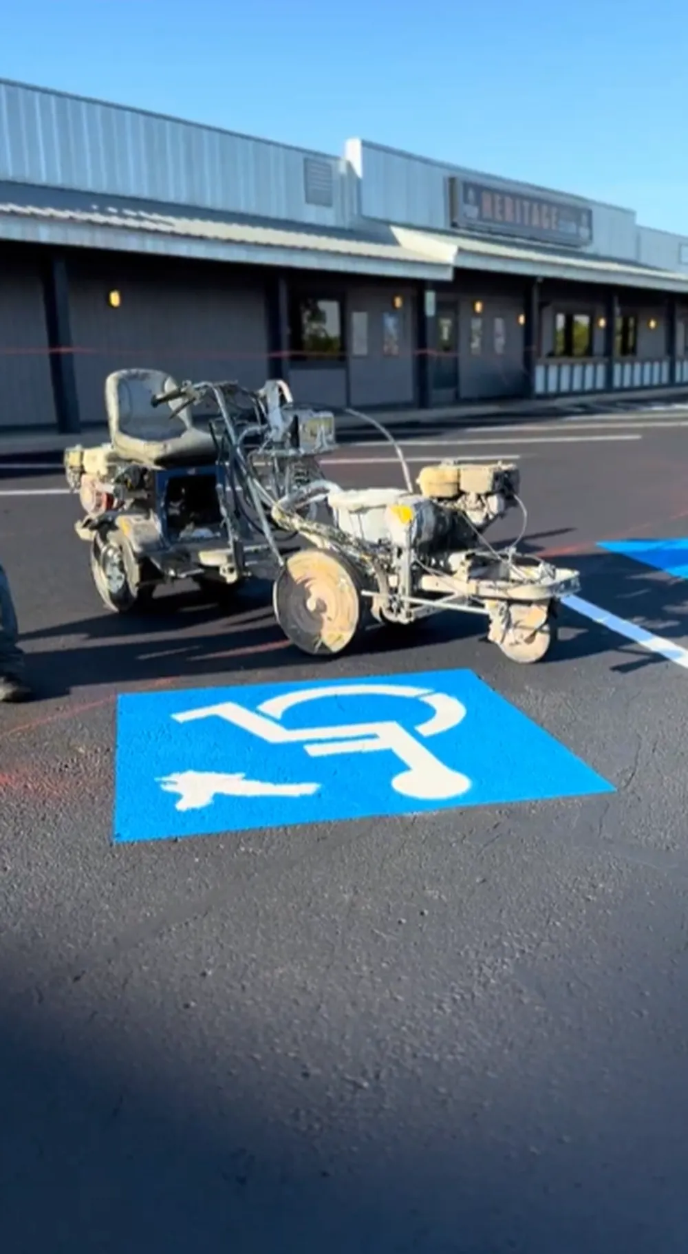 Freshly painted blue ADA handicap parking symbols with line striping machine in a commercial parking lot at Heritage Social Club in Boise, Idaho – Superior Striping