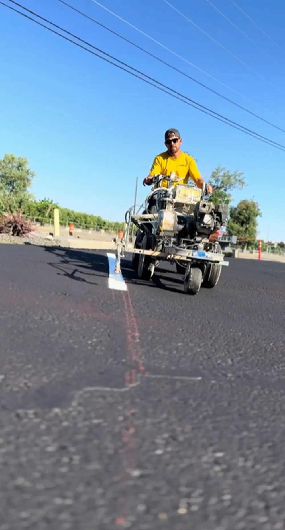 Superior Striping technician operating a ride-on line striping machine applying fresh white lines on a parking lot in Boise, Idaho