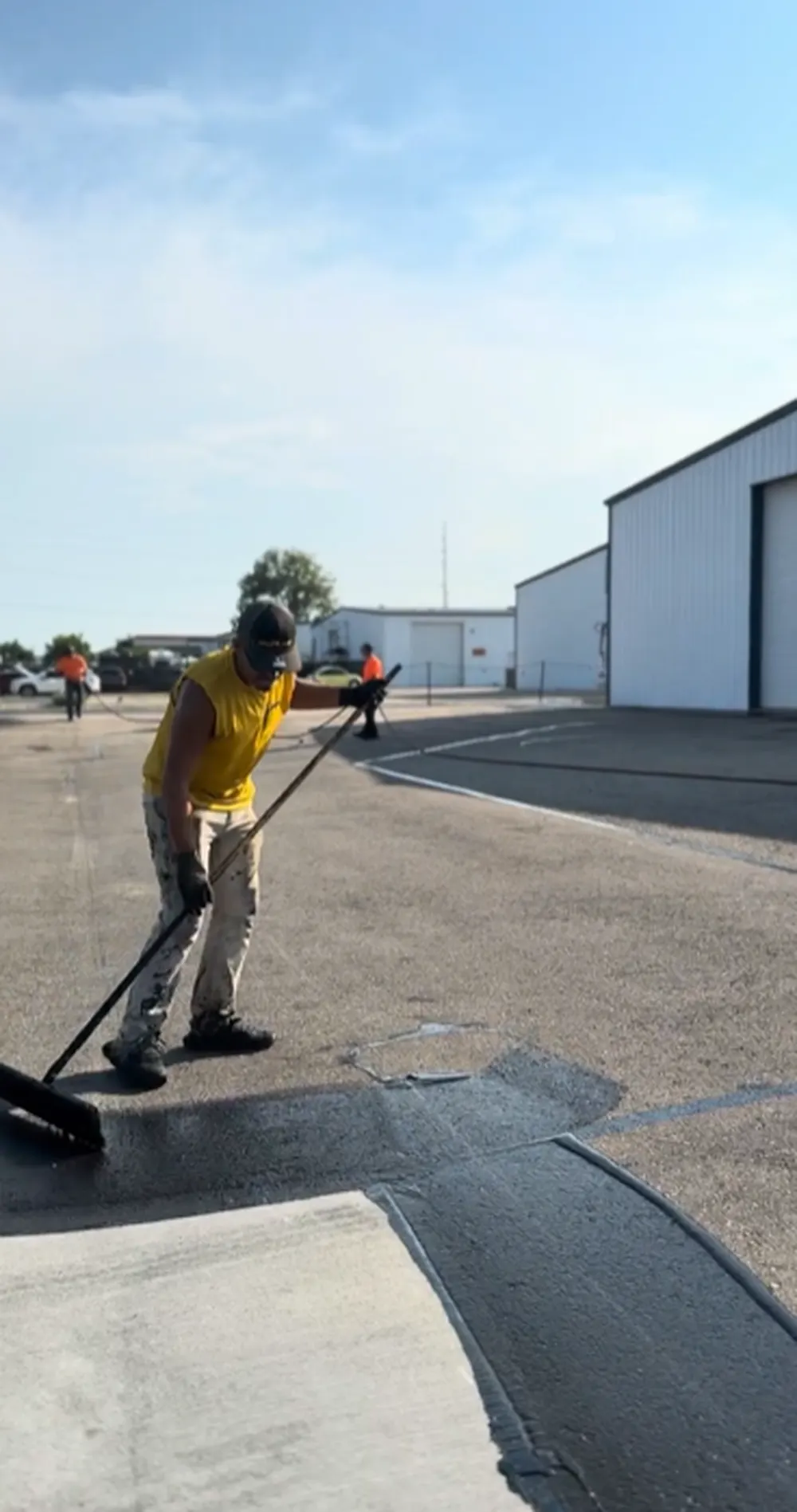 Superior Striping Crew Sealcoating Commercial Parking Lot Next to Industrial Building in Nampa ID