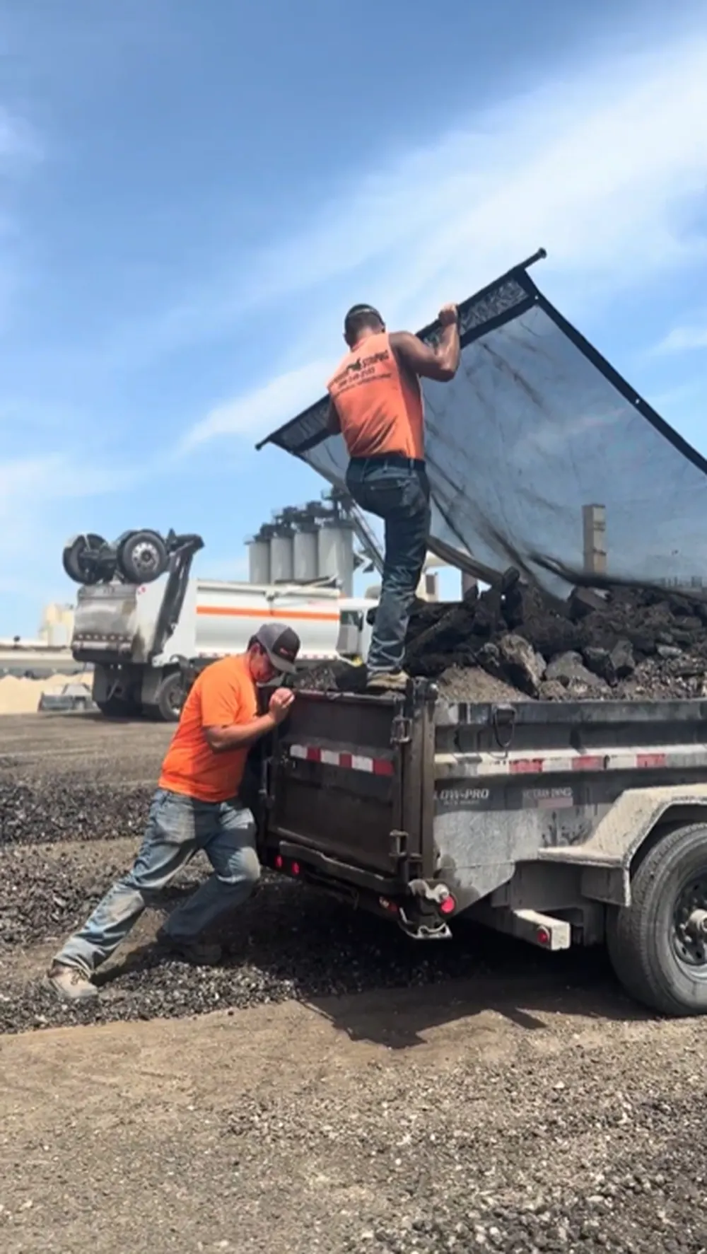 Superior Striping Crew Opening Tarp Cover on Asphalt Dump Trailer in Boise, Idaho