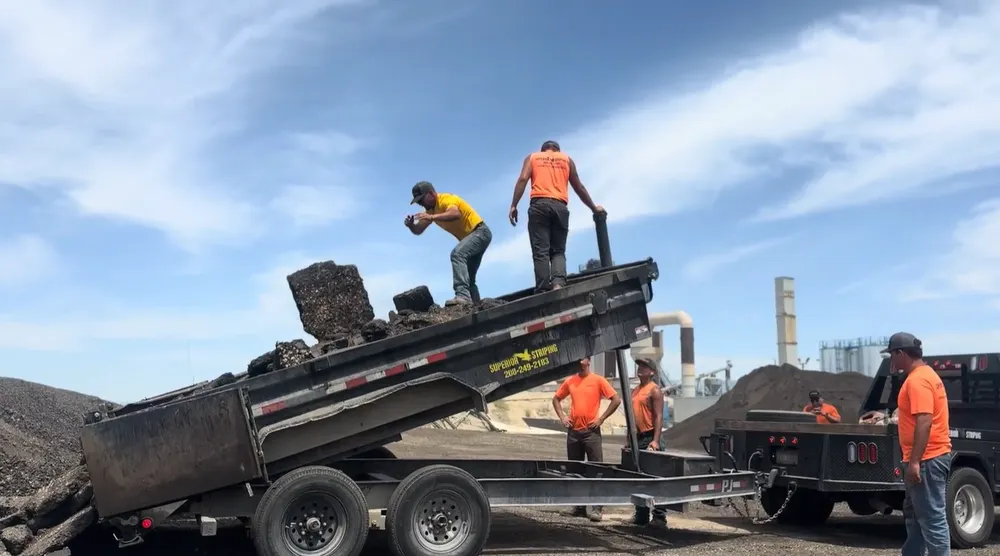 Superior Striping Crew Unloading Asphalt from Dump Trailer in Boise, Idaho