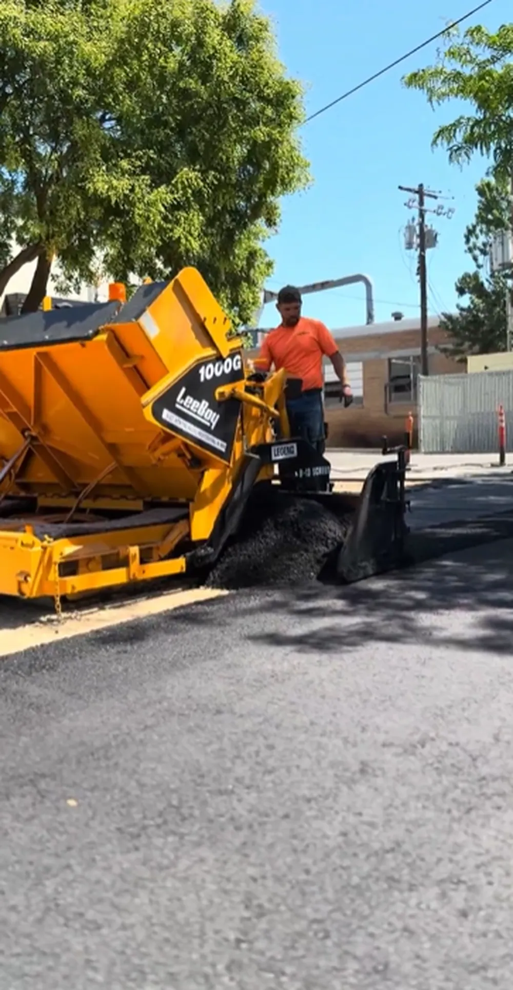 Superior Striping Operator Running Leeboy 1000G Paver Laying Fresh Asphalt on Commercial Parking Lot in Boise, Idaho