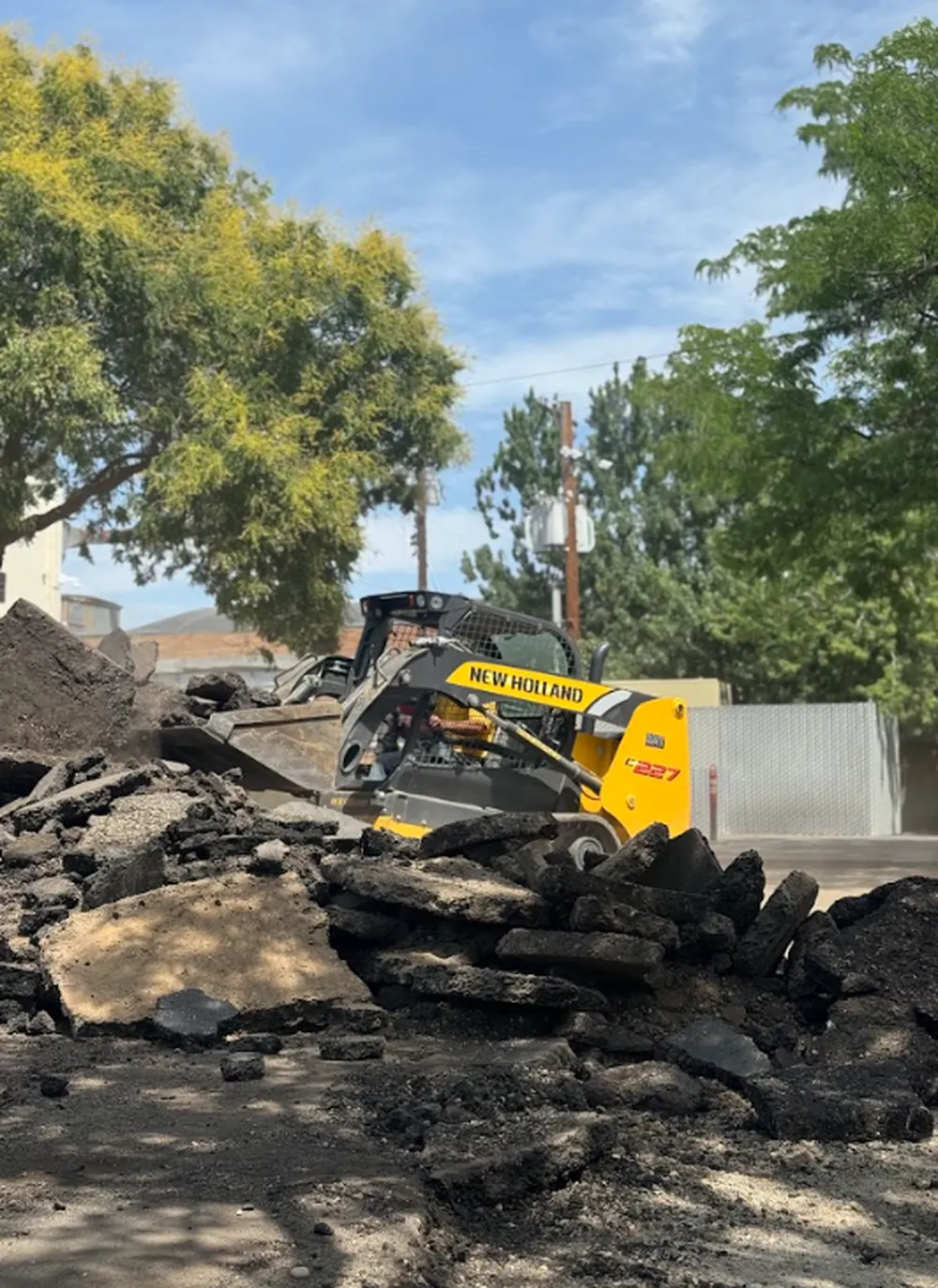 Superior Striping New Holland C227 Skid Steer Clearing Asphalt Debris in Boise, Idaho