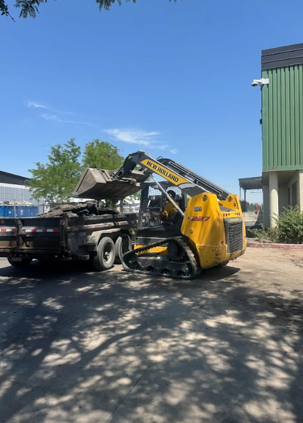 Superior Striping New Holland Skid Steer Dumping Asphalt into Trailer in Boise, Idaho