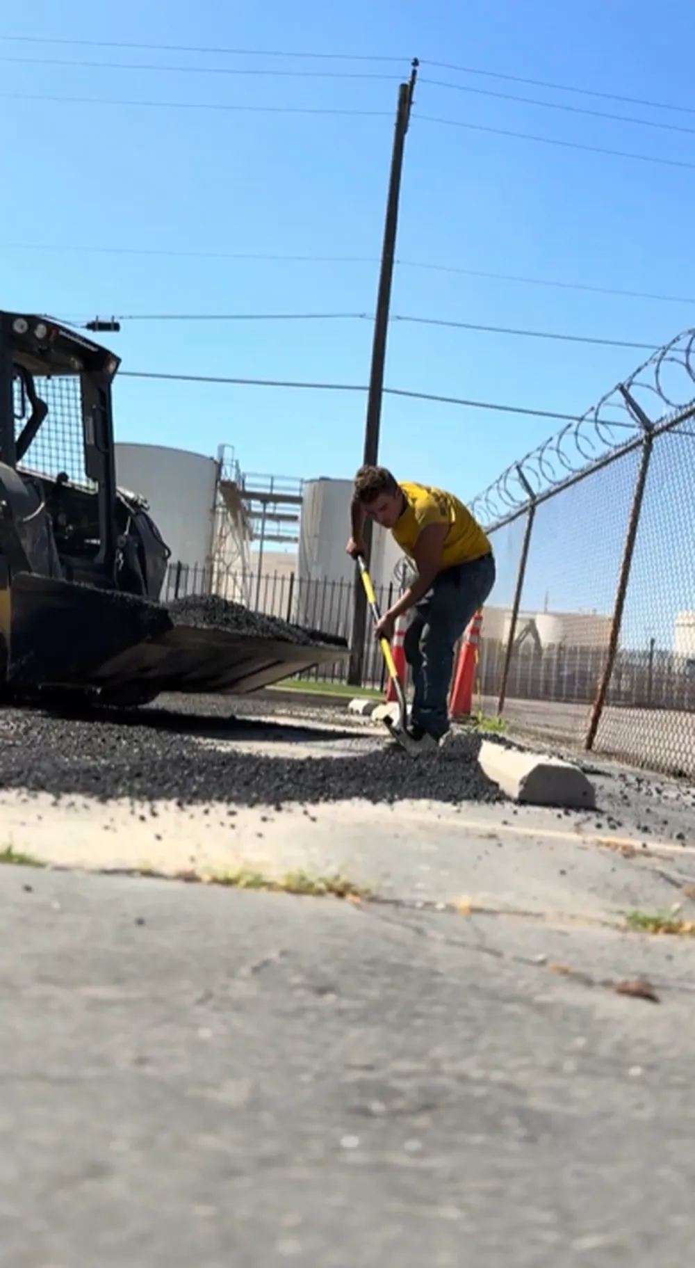 Superior Striping Worker Hand Raking Gravel Base Along Curb During Parking Lot Tear Out and Replacement in Boise, Idaho