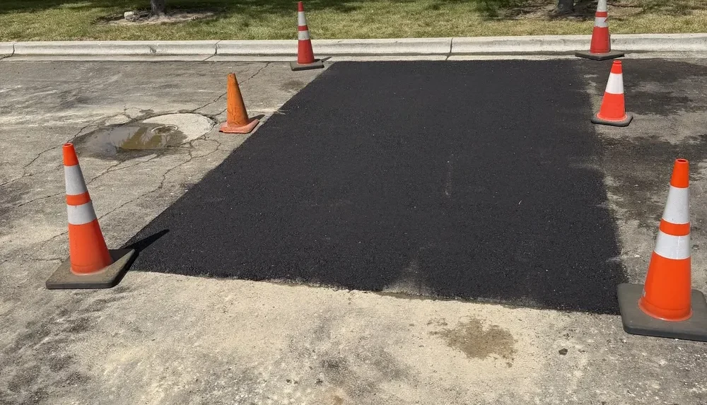 Completed asphalt patch on a parking lot cordoned off with safety traffic cones in Boise Idaho