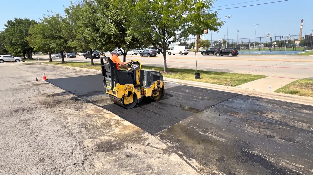 Roller compacting fresh asphalt patch on a gas station parking lot in Boise Idaho