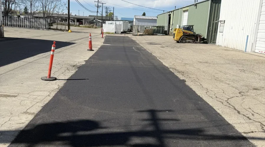 Professional asphalt patching and surface repair on a commercial access road in Boise, Idaho, performed by Superior Striping.